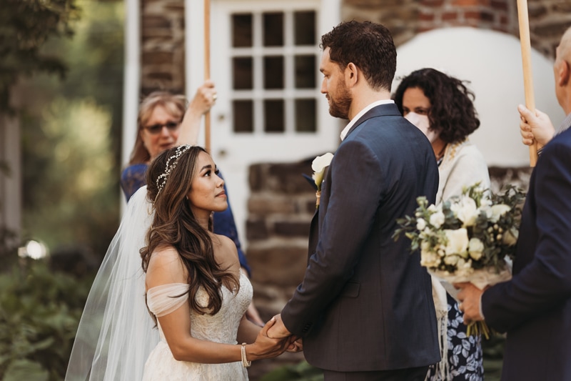 Wedding Photographer, a bride and groom gaze into each other's eyes as they exchange vows