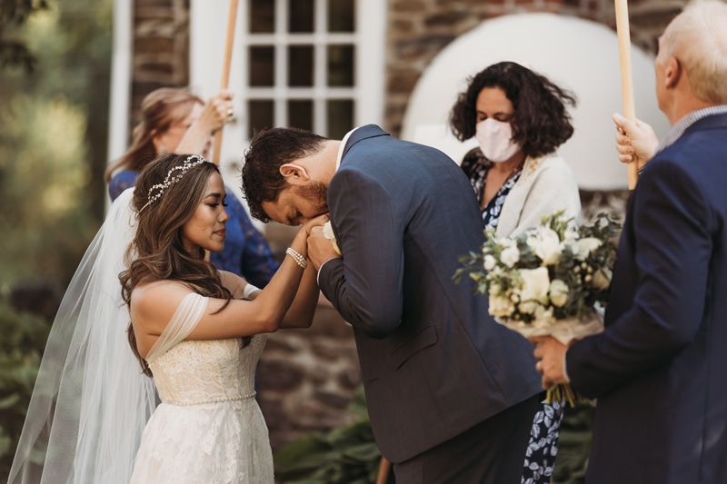 Wedding Photographer, a groom kisses his bride's hands during wedding ceremony