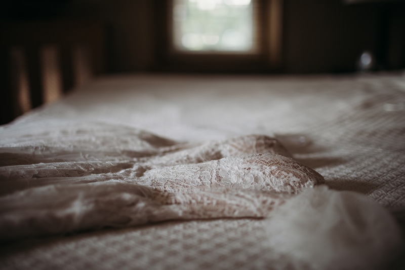 Wedding Photographer, a wedding dress lays on the bed
