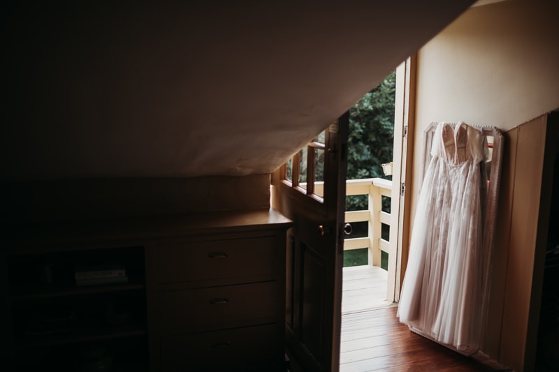 Wedding Photographer, a wedding dress hangs up near cabin door