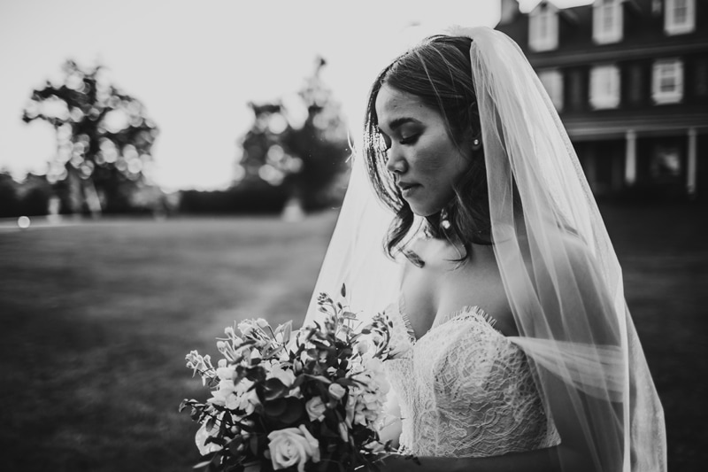 Wedding Photographer, bride holds her floral bouquet on the estate lawn