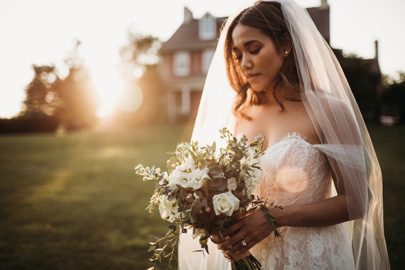 Wedding Photographer, a bride looks at her wedding bouquet