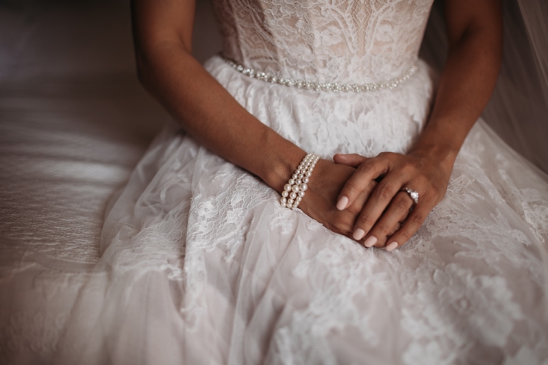 Wedding Photographer, a bride folds her hands on her lap