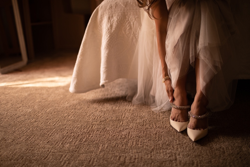 Wedding Photographer, a bride puts on her shoes