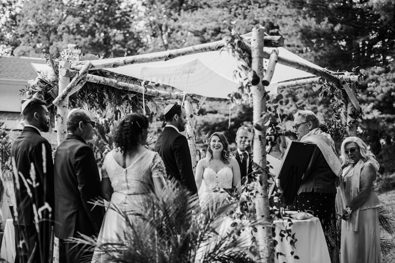 Wedding Photographer, a wedding party looks on as a happy couple exchange their vows