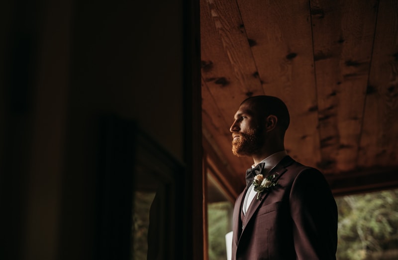 Wedding Photographer, a groom stands in hi suit