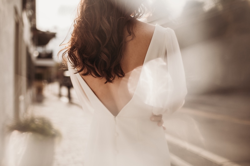 Wedding Photographer, a bride walks in the village, the light shines on her