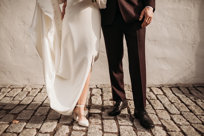 Wedding Photographer, a bride and groom stand with each other, their shoes on cobblestones