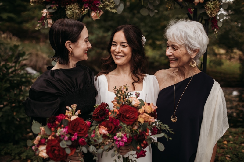 Wedding Photographer, a bride stands with her mother and sister smiling