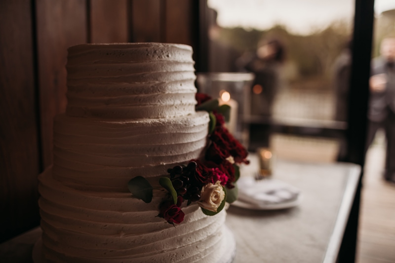 Wedding Photographer, a wedding cake has flowers wrapped around it