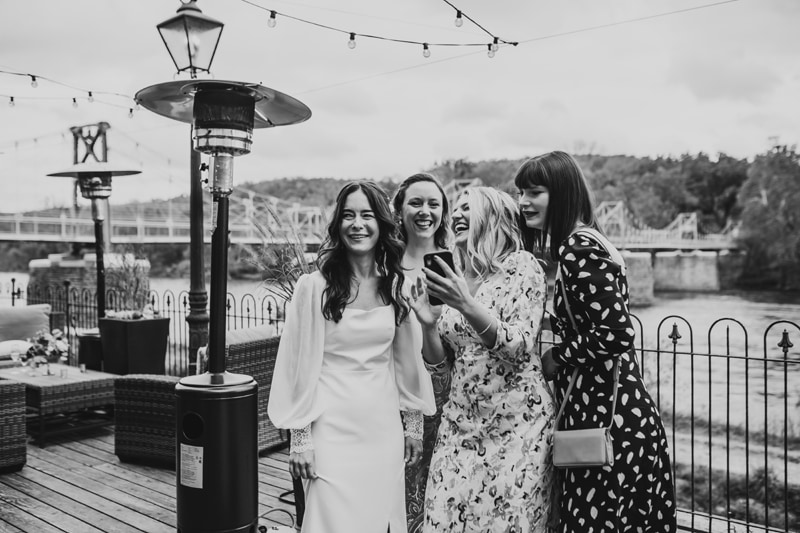 Wedding Photographer, the bride laughs with her friends at her reception